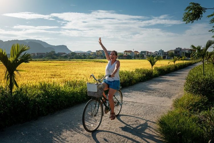 Selective,Focus.,Woman,Tourist,Riding,A,Bicycle,Through,Rice,Fields